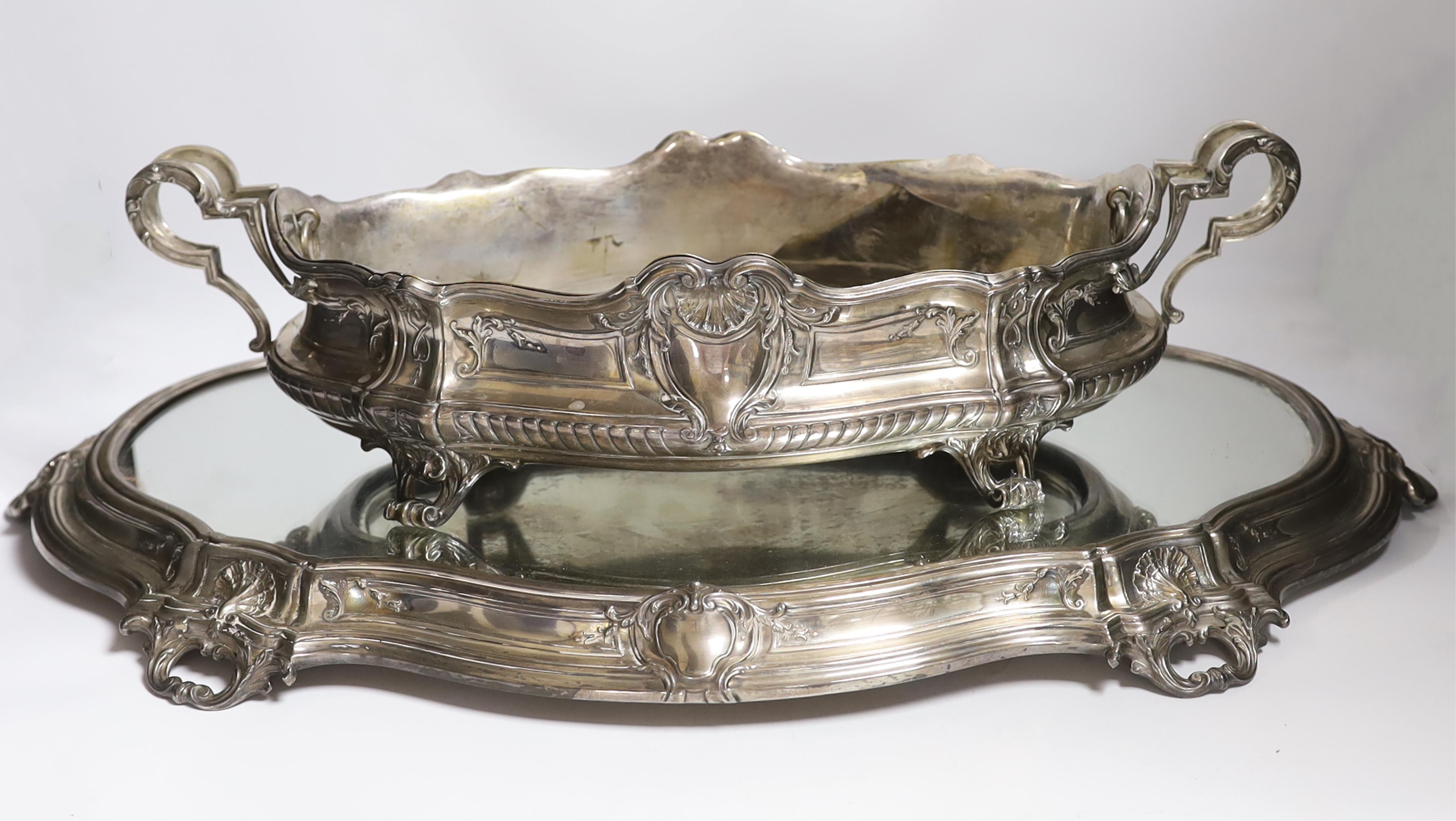 A large ornate Belgian? 800 standard white metal two handled oval centrepiece, 53cm, 46.1oz, with a base metal liner, on a similar 800 standard white metal mounted mirrored stand, 70cm.